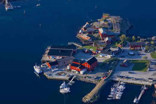 Typical norwegian fishing harbor in Reine on Lofoten islands with red wooden buildings