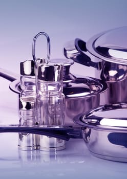 Stainless steel pepperbox and saltcellar over utensil background