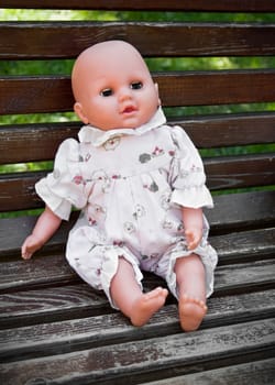 Alone baby doll sitting in the park.