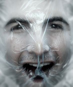 Young man close up with a plastic bag on his head-NOTE:Soft blur was added to simulate a ghost effect.