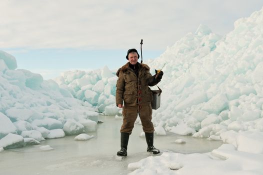 Ice Fishing. Fisherman with equipment for fishing on Ladoga Lake