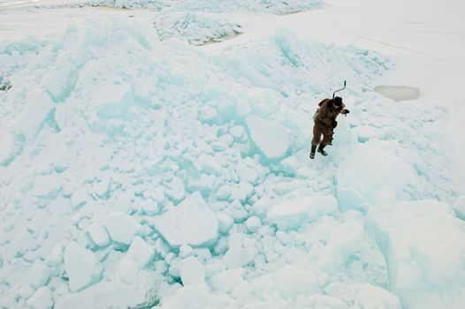  The fisherman clambering on ice blocks.