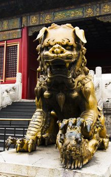 On the left of the entrance in Forbidden city stands a bronze female lion with a cub under her paw