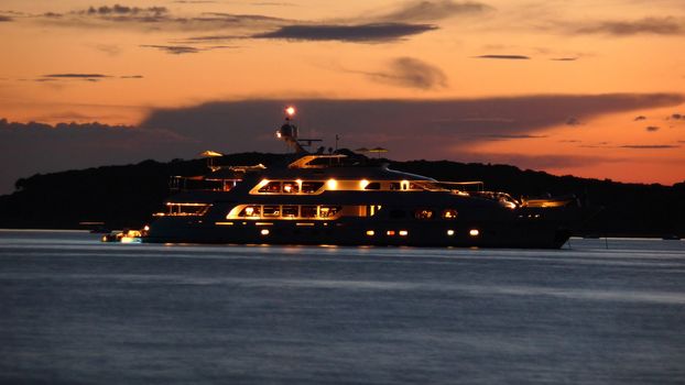 Illuminated luxury yacht at dusk on sea