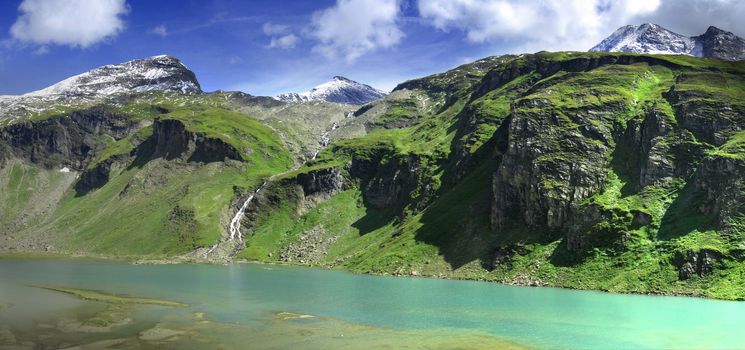 Alpine peaks covered by snow and a beautiful crystal clear lake