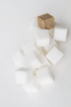 stack of white sugar cube with one brown sugar cube falling down