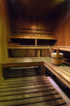 Empty wooden sauna with a bucket of water 