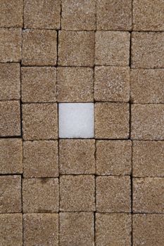 Texture of sugar cube, mostly brown with one white