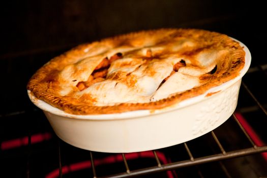 three apple pies cooking in the oven