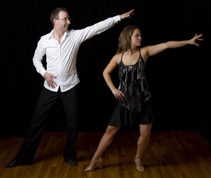 couple dancing salsa in the middle of a pose