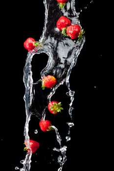 water splash with ripe red strawberry over black background