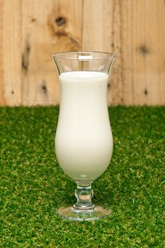 Banana milk shake with real fruit and a wooden wall