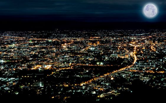 Lights of city in night time scene with blue moon in chiangmai of thailand