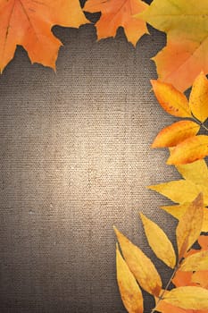 Border made from autumn leaves on canvas background with free space for text