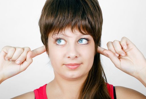 blue-eyed girl plugs fingers in his ears