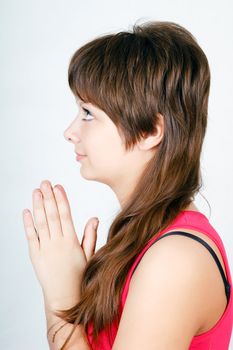 blue-eyed teen girl praying. View from the profile