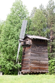 An old wooden windmill in a forest
