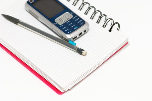 A pencil, telephone and notebook on the white background