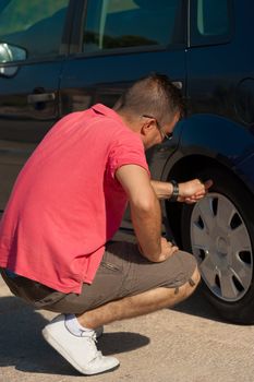 Male motorist checking the state of his tyres