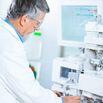 Senior male researcher carrying out scientific research in a lab (shallow DOF; color toned image)