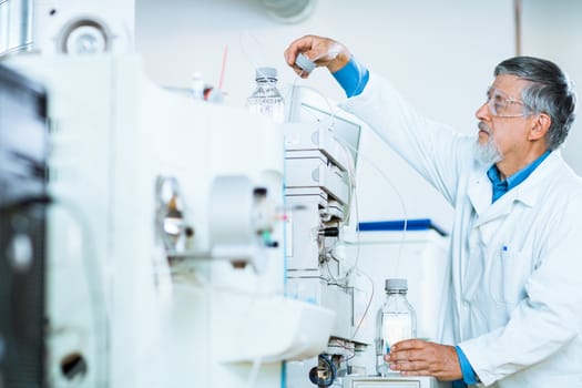 Senior male researcher carrying out scientific research in a lab (shallow DOF; color toned image)