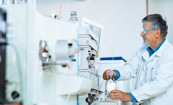 Senior male researcher carrying out scientific research in a lab (shallow DOF; color toned image)