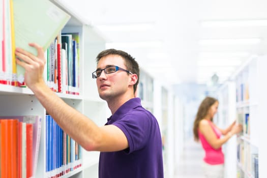 Handsome college student in library (shallow DOF; color toned image)