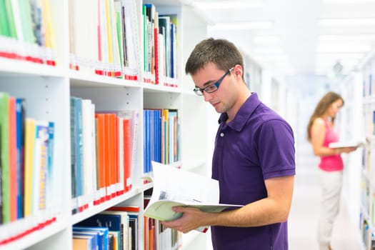 Handsome college student in library (shallow DOF; color toned image)