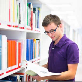 Handsome college student in library (shallow DOF; color toned image)