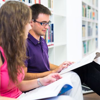 Two college students in library (color toned image; shallow DOF)