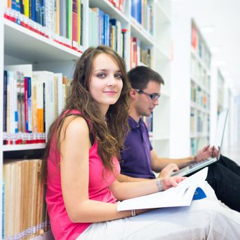 Two college students in library (color toned image; shallow DOF)