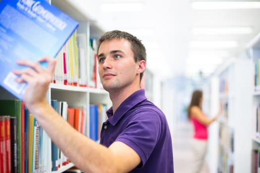 Handsome college student in library (shallow DOF; color toned image)