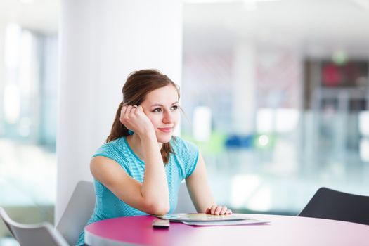 Pretty young woman using her mobile phone/speaking on the phone in a public area (shallow DOF; color toned image)