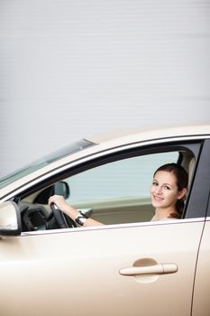 Pretty young woman driving her new car