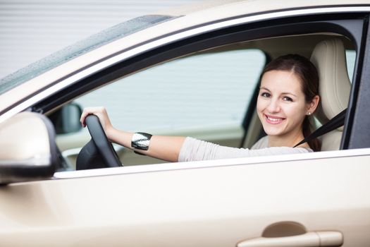 Pretty young woman driving her new car