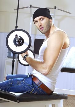 man makes exercises with bar in exercise room