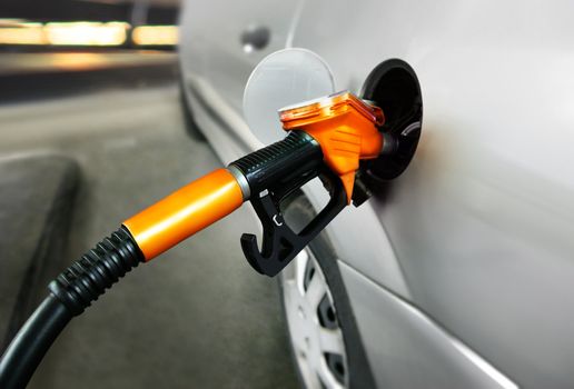 grey car at gas station being filled with fuel