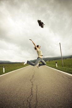 Young woman jumping  on the long empty street.