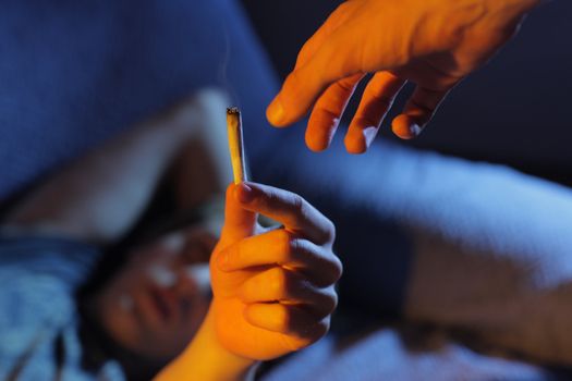 Close up of two young adults smoking a joint