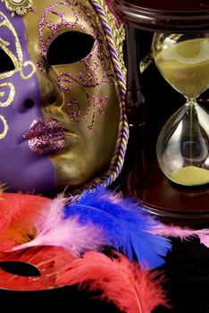 Colorful violet and gold venetian mask and hourglass