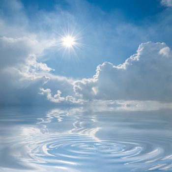 Blue sky with clouds and sun reflection in water with waves