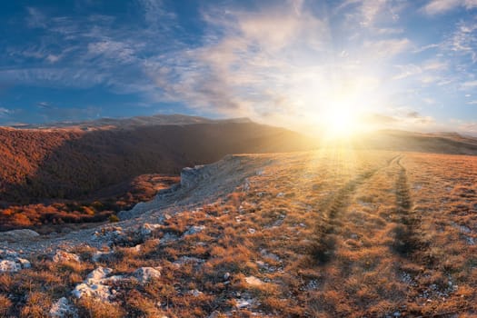 Landscape in mountains with road on the top and majestic sunset on background