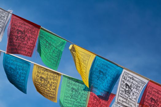 Buddhist tibetan prayer flags flying with blue sky