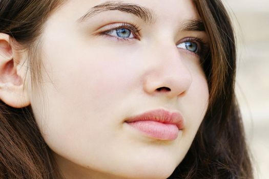 Portrait of s beautiful hopeful or pensive young woman with fair skin and light blue and green eyes, simple and natural.