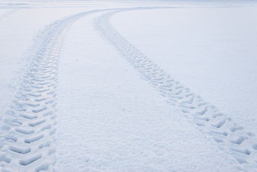 Tire trace on snow leaving to the horizon