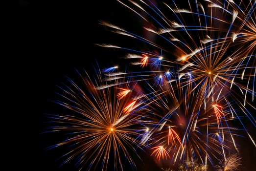 Beautiful colorful holiday fireworks on the black sky background, close-up, long exposure