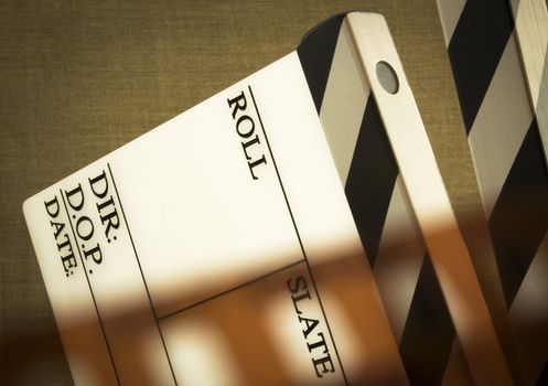 fine image of clapboard with film tape on brown background