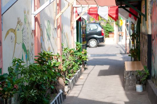 Narrow street with graffiti on the wall in Yogyakarta, Indonesia