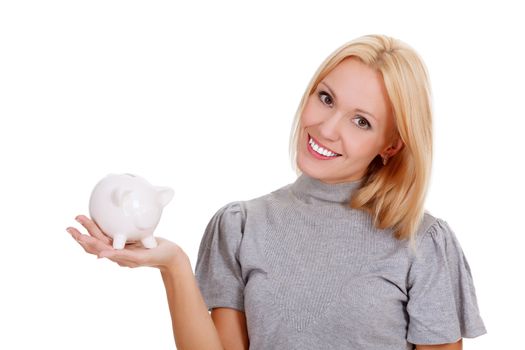 Smiling woman with piggy bank posing against white background