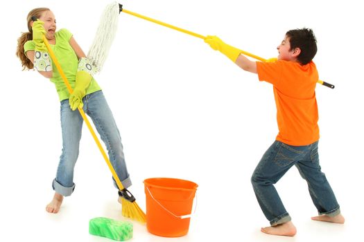 Spring cleaning 9 year old kids playing with stinky mop over white background barefoot in casual.